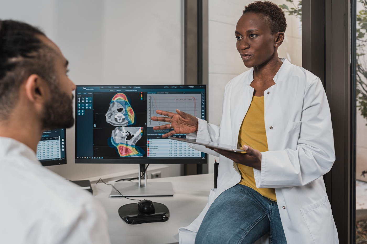 Two clinicians reviewing ranked clinical evidence and imaging results on screen in a healthcare RAG workflow